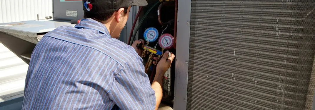 HVAC technician servicing a condenser unit in Belton