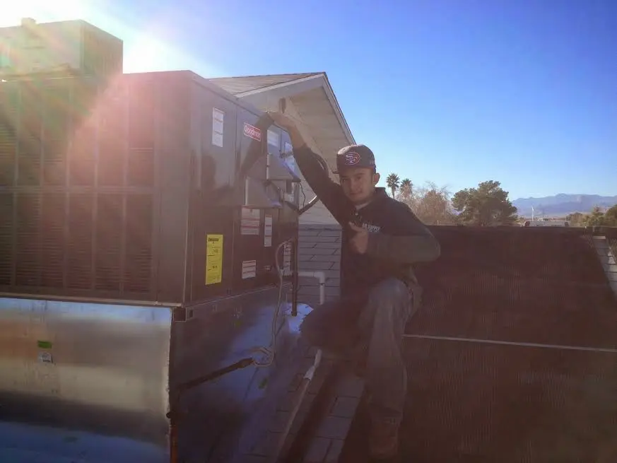 HVAC technician performing AC Tune-Up on a rooftop unit in Belton